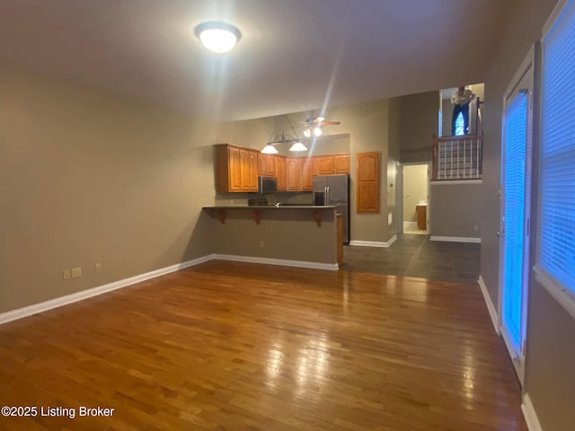 living room with lofted ceiling, dark hardwood / wood-style floors, and ceiling fan