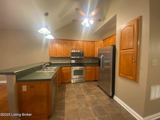 kitchen featuring lofted ceiling, sink, hanging light fixtures, kitchen peninsula, and stainless steel appliances