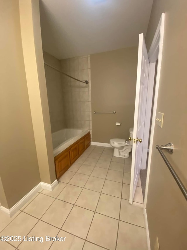 bathroom featuring tiled shower / bath combo, tile patterned floors, and toilet