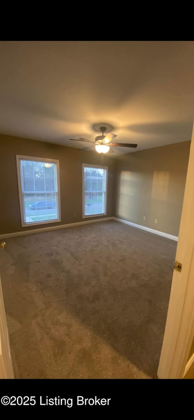 carpeted spare room with ceiling fan