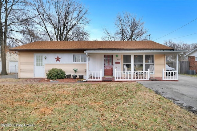 ranch-style home with a front yard, central AC unit, and covered porch