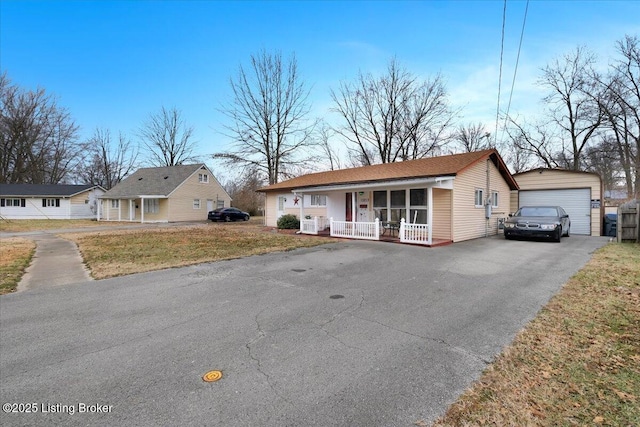 ranch-style home with a garage, an outdoor structure, covered porch, and a front lawn