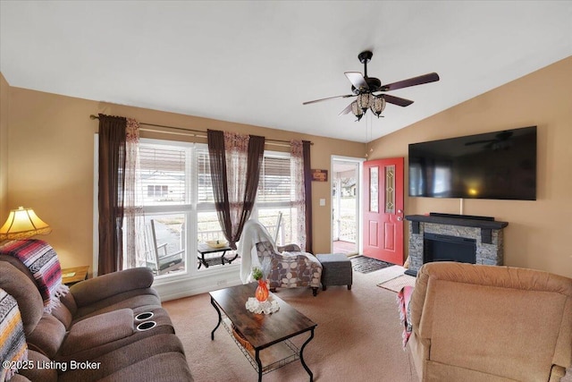 living room with ceiling fan, lofted ceiling, light carpet, and a fireplace