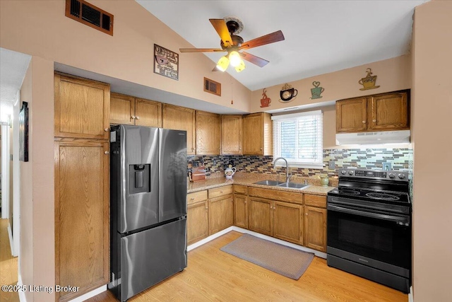 kitchen featuring sink, vaulted ceiling, stainless steel fridge with ice dispenser, electric range, and decorative backsplash