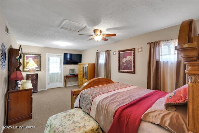 carpeted bedroom featuring ceiling fan and a textured ceiling