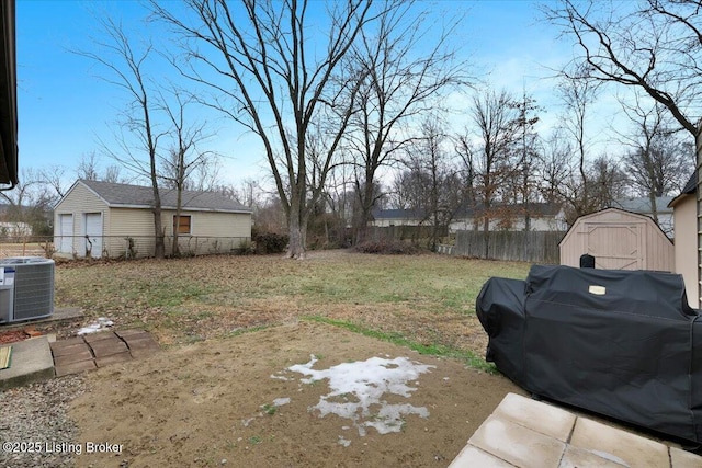 view of yard featuring central AC unit and a shed