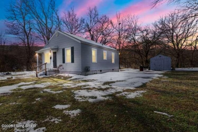 property exterior at dusk with a storage unit