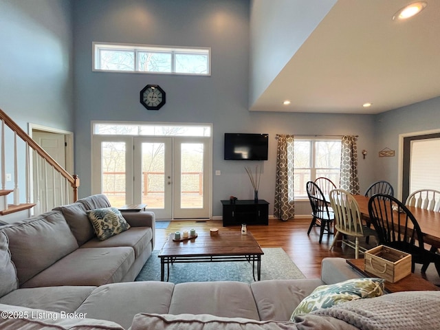 living room with hardwood / wood-style flooring, a high ceiling, and french doors