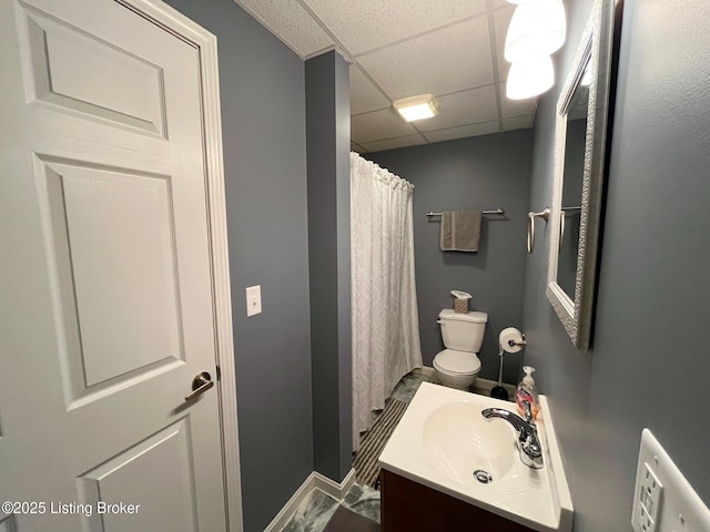 bathroom with vanity, a drop ceiling, and toilet