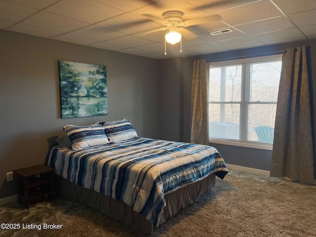 carpeted bedroom featuring a drop ceiling and ceiling fan