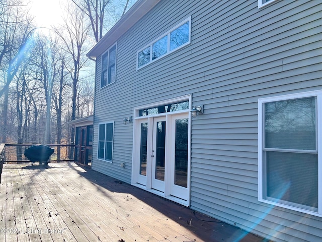 wooden terrace with a grill and french doors