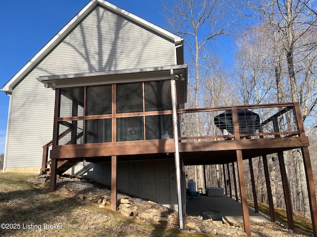 back of house featuring a wooden deck and a sunroom