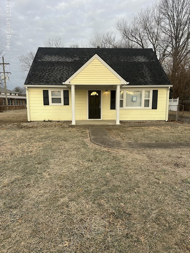 view of front of property featuring roof with shingles and fence