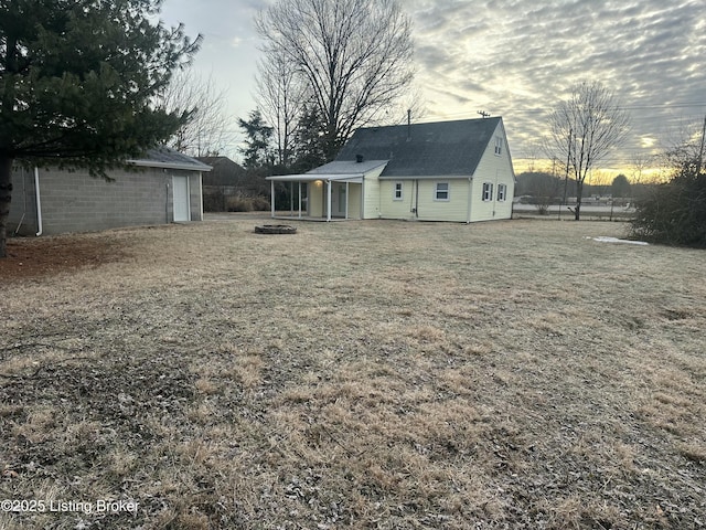 yard at dusk featuring an outdoor fire pit