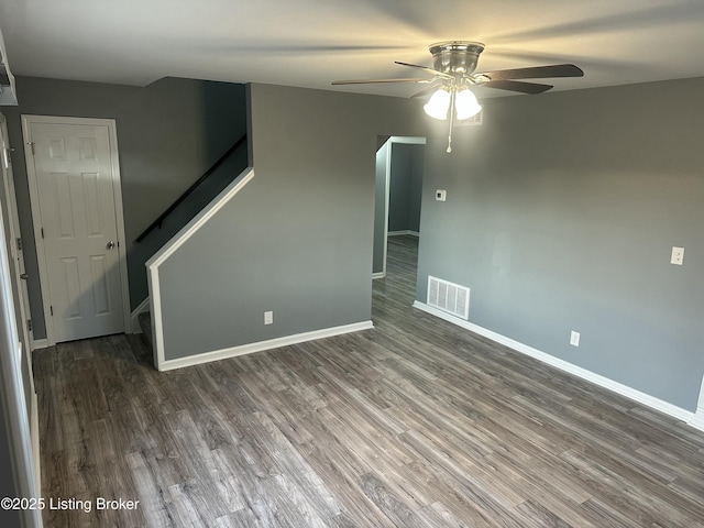 unfurnished room featuring dark wood-type flooring and ceiling fan