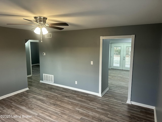 empty room featuring ceiling fan, dark hardwood / wood-style flooring, and french doors