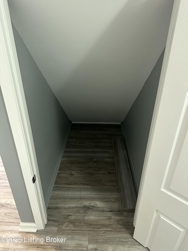 staircase featuring baseboards and wood finished floors