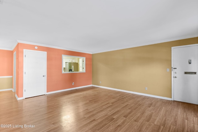 spare room with crown molding and light wood-type flooring