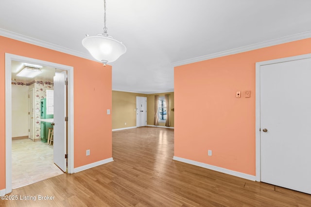 spare room with crown molding and light wood-type flooring