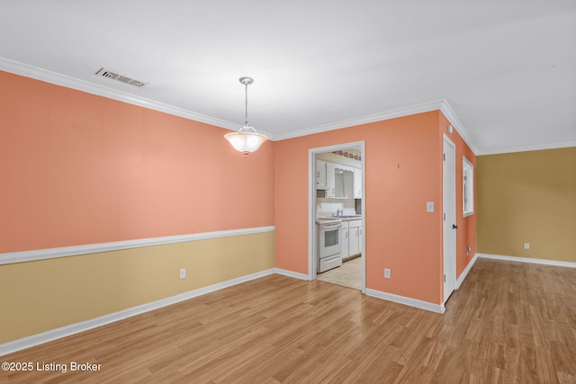 interior space with crown molding, pendant lighting, light hardwood / wood-style floors, and electric stove