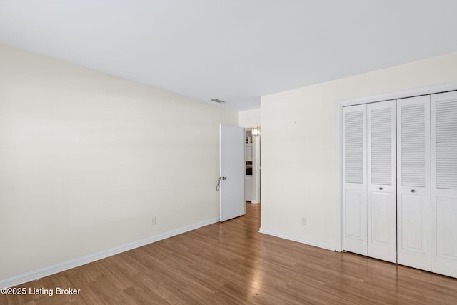 unfurnished bedroom with hardwood / wood-style flooring and a closet