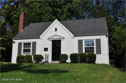 view of front of home featuring a front lawn and a chimney