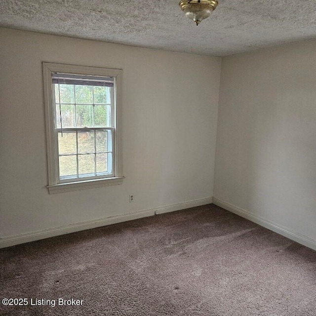 carpeted spare room with a textured ceiling