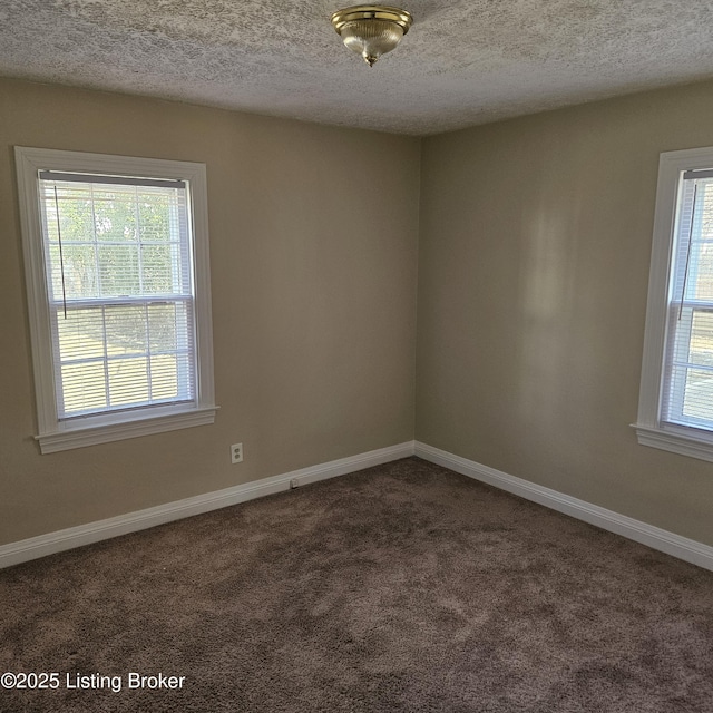 unfurnished room with dark colored carpet, a textured ceiling, and baseboards