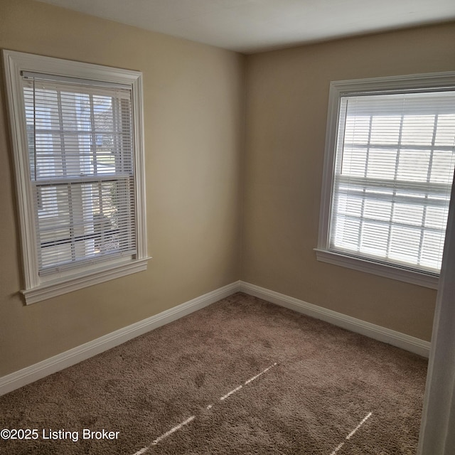 unfurnished room featuring carpet and baseboards