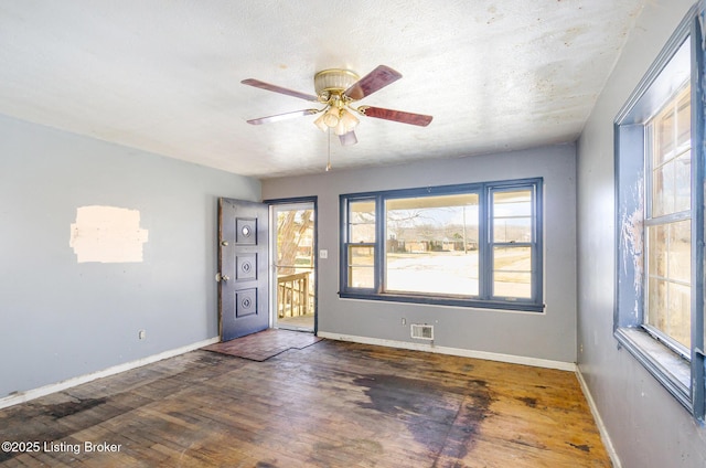 empty room with ceiling fan and dark hardwood / wood-style floors