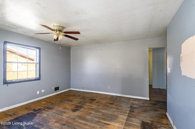 empty room featuring dark wood-type flooring and ceiling fan