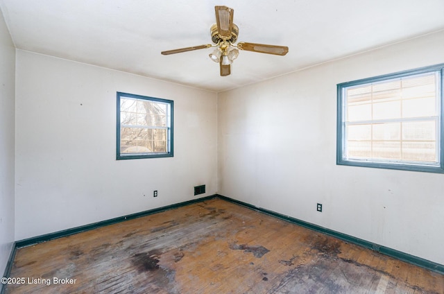 empty room with dark hardwood / wood-style flooring and ceiling fan