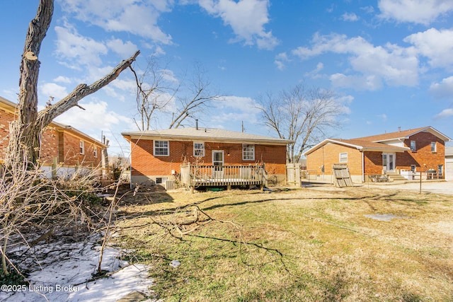 rear view of house featuring a wooden deck and a yard