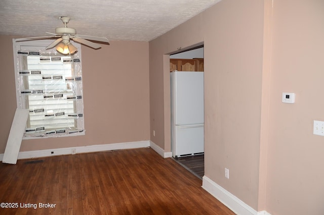 spare room featuring ceiling fan, dark hardwood / wood-style floors, and a textured ceiling