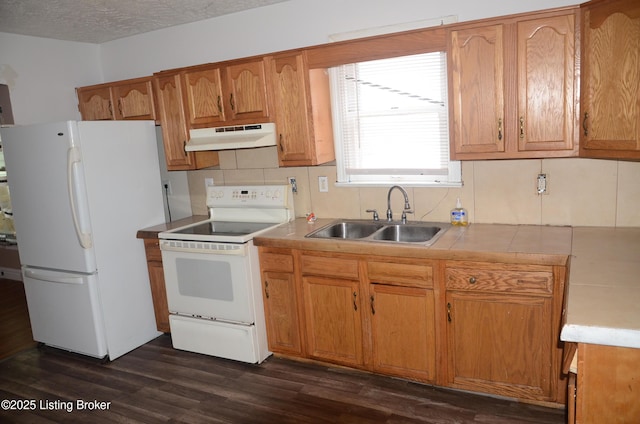 kitchen featuring dark hardwood / wood-style floors, sink, backsplash, white appliances, and a textured ceiling