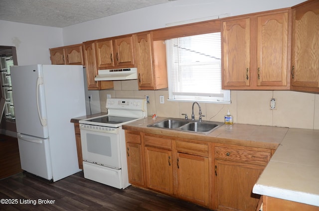 kitchen featuring sink, white appliances, a textured ceiling, dark hardwood / wood-style flooring, and decorative backsplash