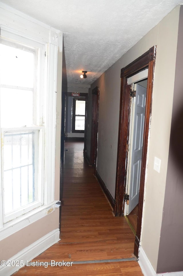 hall featuring dark hardwood / wood-style flooring and a textured ceiling