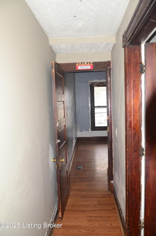 hall with dark hardwood / wood-style floors and a textured ceiling