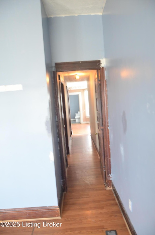 hallway with hardwood / wood-style flooring