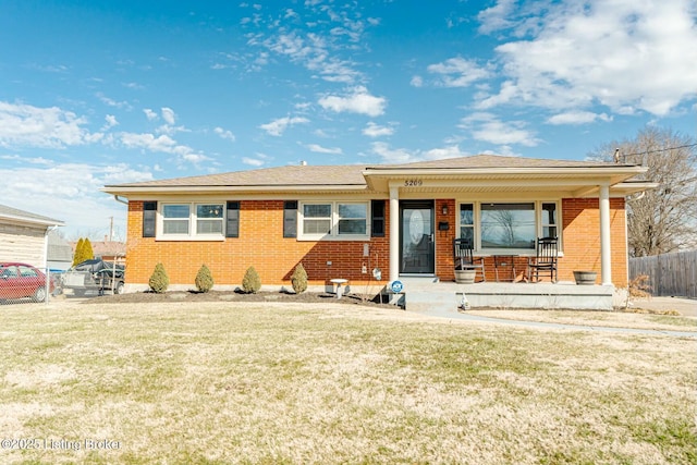 ranch-style house with brick siding, a porch, a front yard, and fence