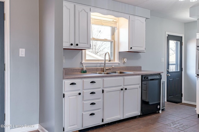 kitchen with black dishwasher, light countertops, white cabinetry, a sink, and light tile patterned flooring