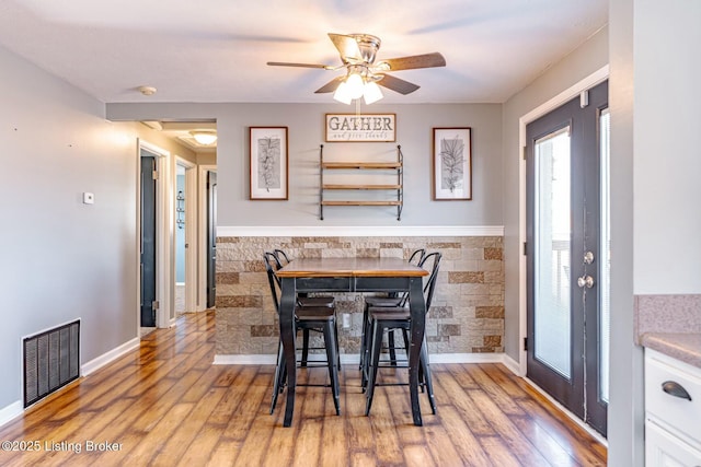 dining space featuring light wood-style floors, french doors, visible vents, and ceiling fan