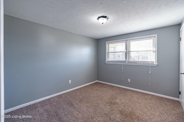 carpeted empty room featuring a textured ceiling and baseboards