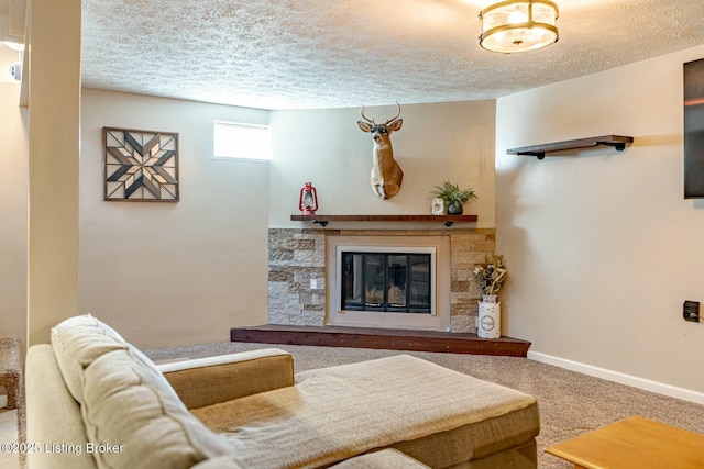 carpeted living area with a textured ceiling, a stone fireplace, and baseboards