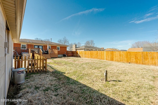 view of yard with a fenced backyard and a wooden deck