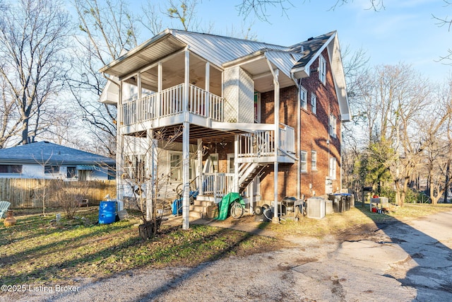 view of front of property featuring central AC unit and a balcony