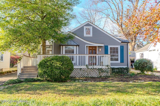 view of front of house with a wooden deck and a front yard