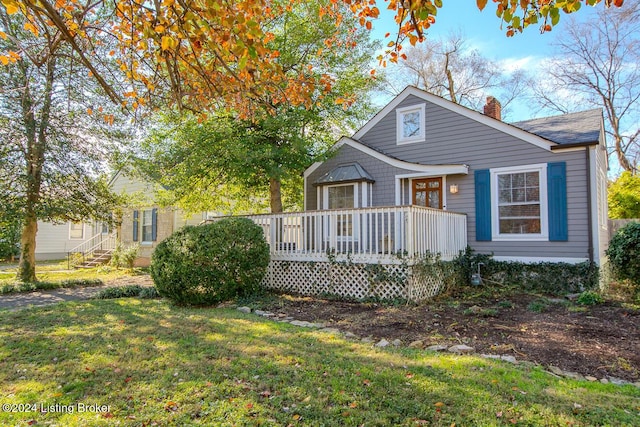 rear view of house featuring a wooden deck and a lawn