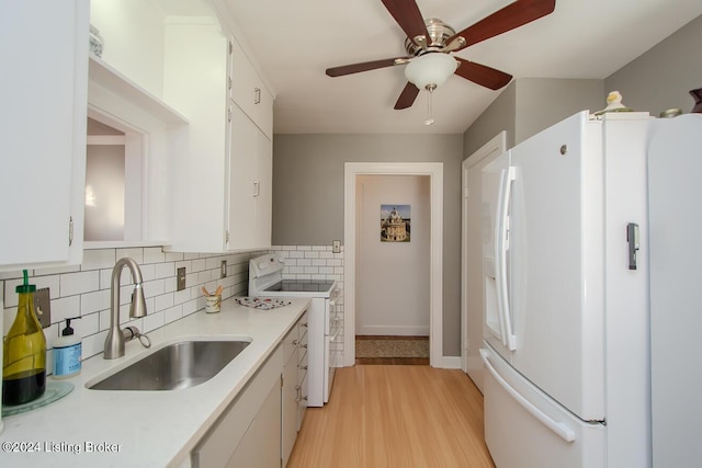 kitchen featuring sink, white cabinetry, light hardwood / wood-style flooring, white appliances, and backsplash