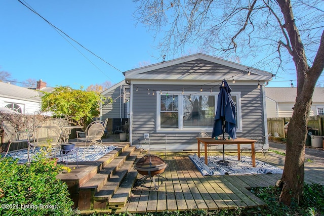 rear view of property with a fire pit and a deck